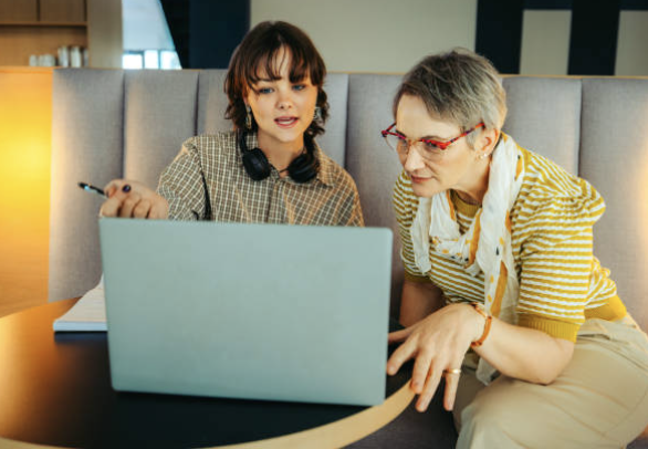 Two colleagues reviewing guidance together on a laptop.